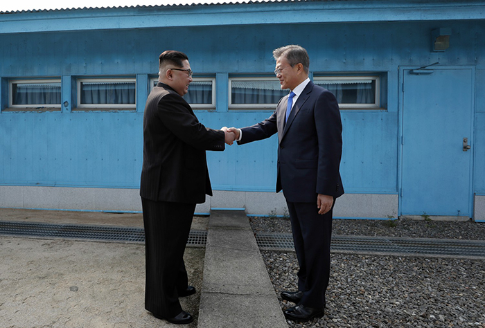  
North Korean leader Kim Jong Un (left) and President Moon Jae-in (right) on April 27 shake hands at the line of demarcation that divides both Koreas. (Pyeongyang Press Corps) 
